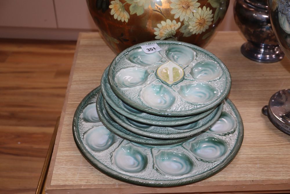 A set of four pottery oyster dishes, and a platter, the platter diameter 37cm